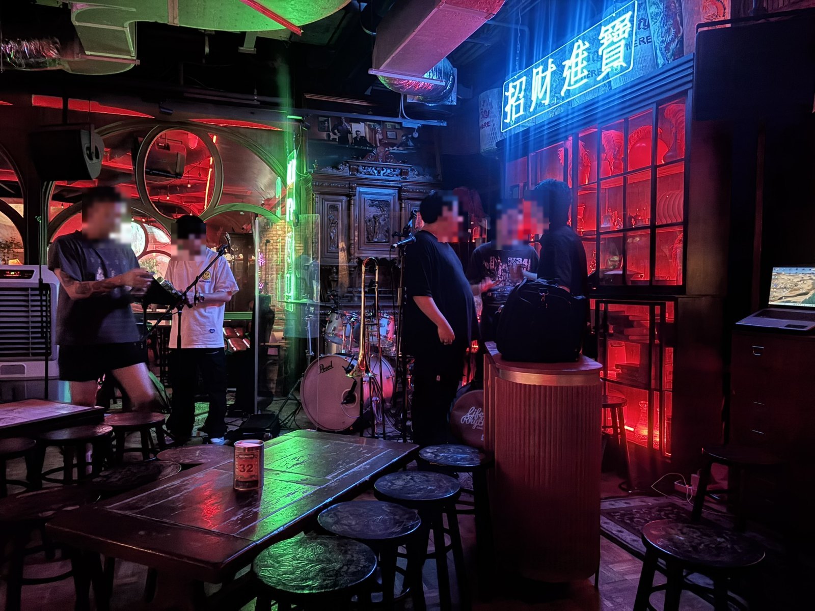 「招財進寶」の青いネオンが光るバーとライブ演奏