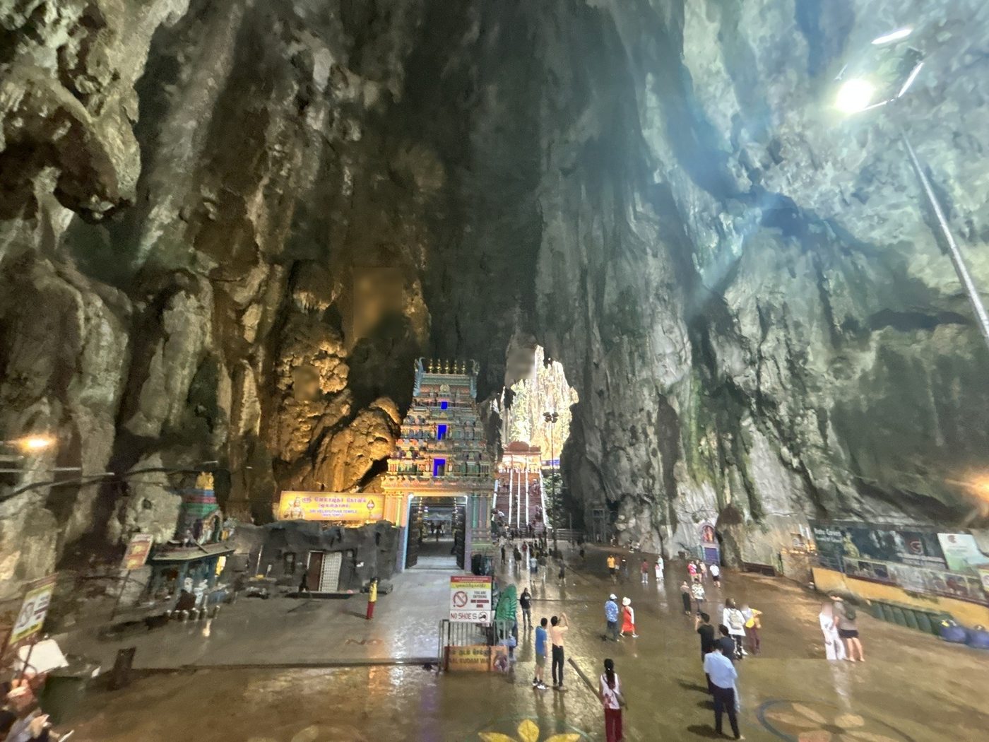 天井の高い洞窟の中。奥に寺院の塔門と、その先の階段