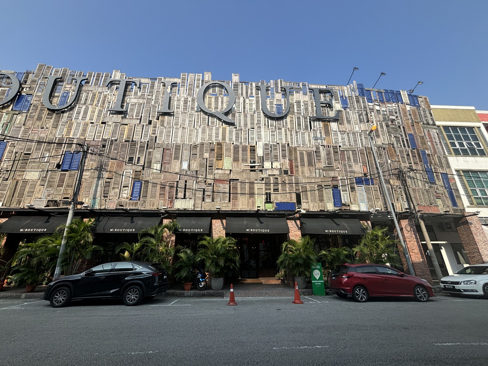 古い木の窓枠や板が壁一面に貼られたM Boutique Hotelの外観