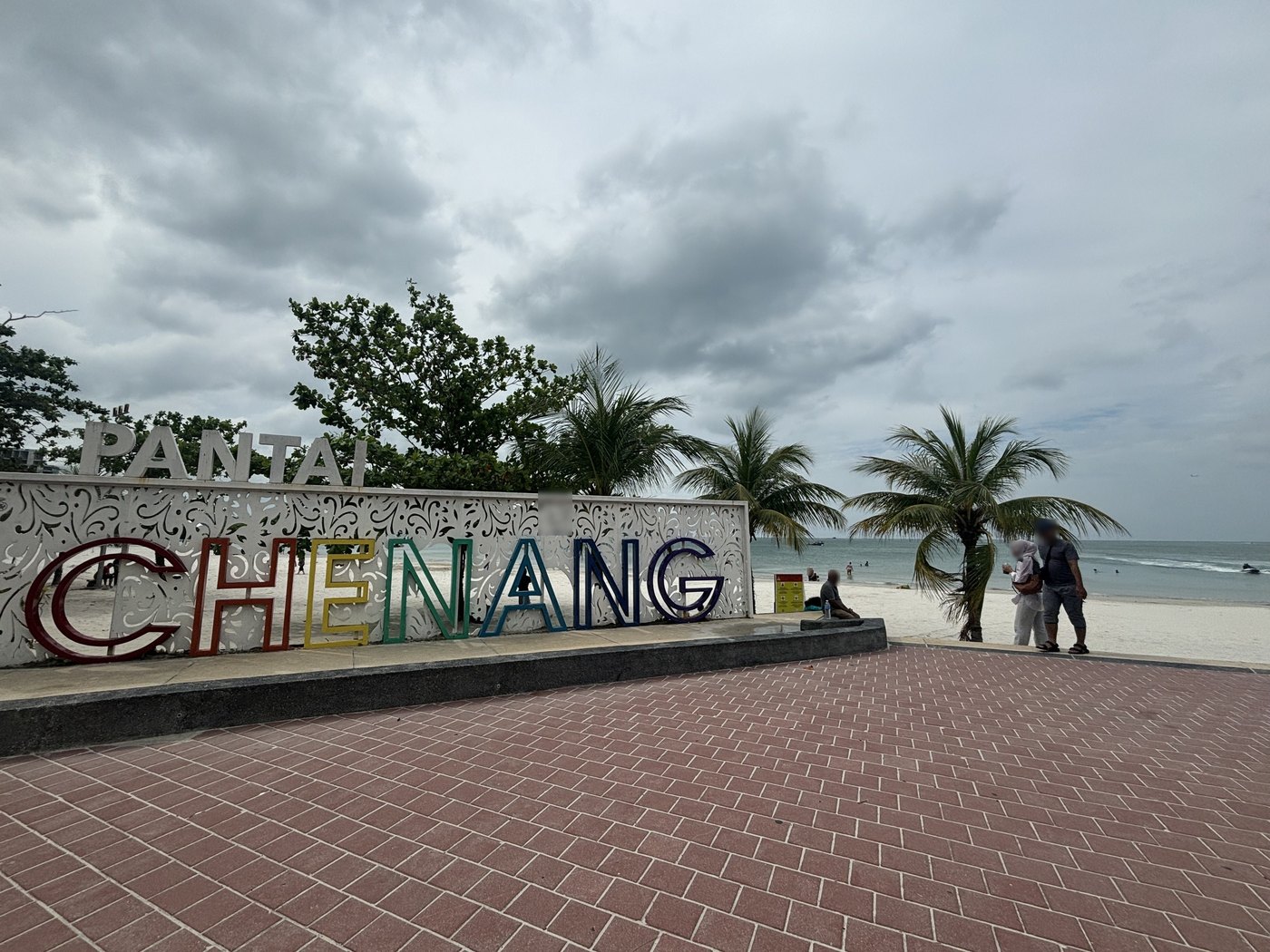 PANTAI CHENANGの大きな文字の看板とヤシの木、その先の浜