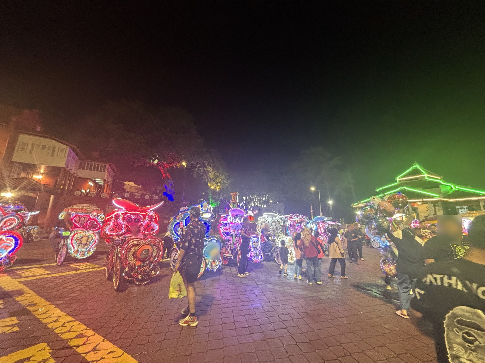 夜の広場を埋める何十台もの電飾トライショー