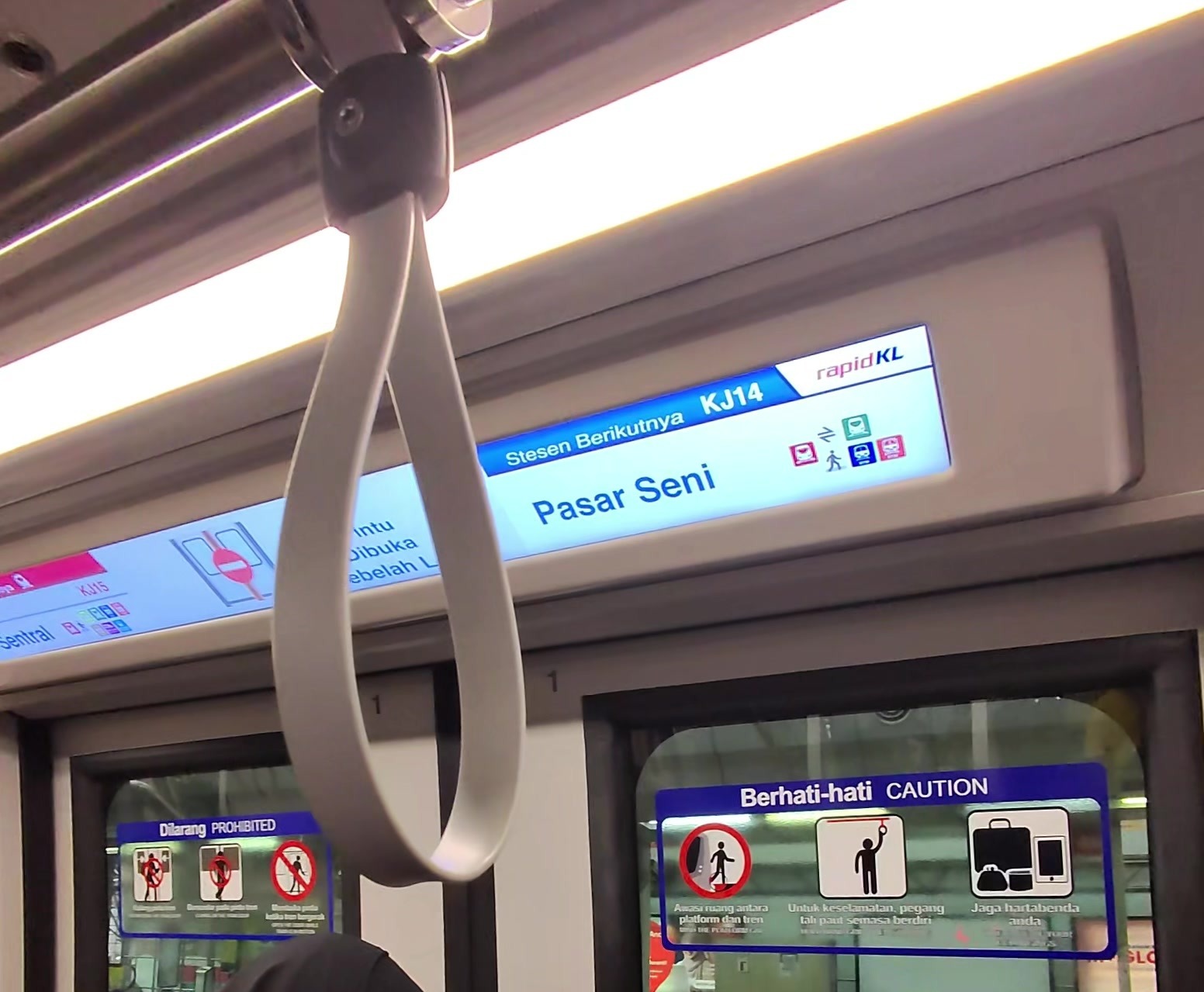 車内のドアの上の表示。Stesen Berikutnya KJ14 Pasar Seni