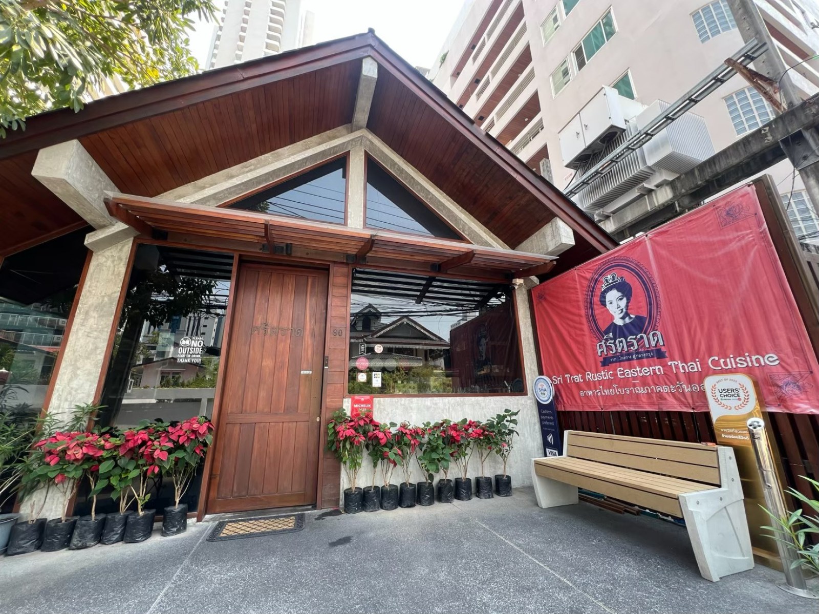木の切妻屋根と赤い看板が出たシートラートの入口